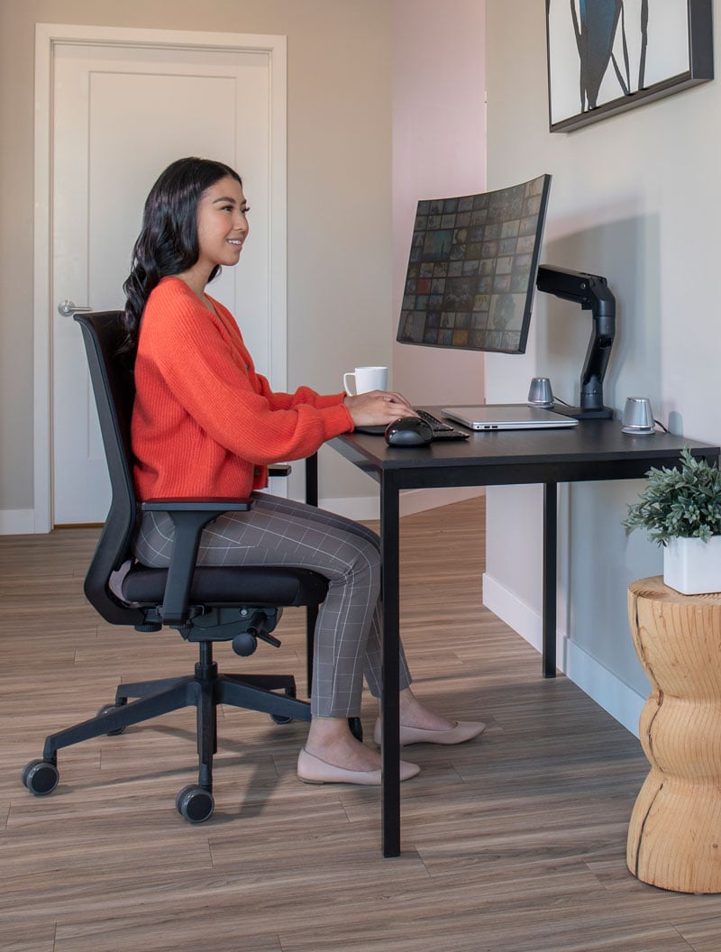 Femme utilisant le bras pour écran HX dans son bureau à domicile